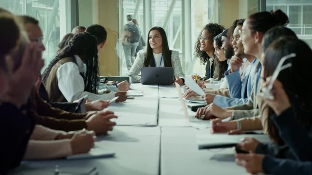 A strong female leader guides a boardroom discussion with professionals around a large table, symbolizing leadership, confidence, and collaboration in a modern workplace.