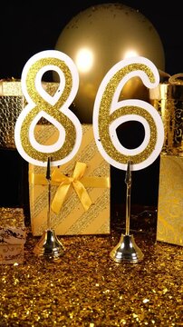 Gold Number 86 with Gold Glitter Confetti Sparkles with Gifts and Balloons for Party Eighty Six 4k Vertical