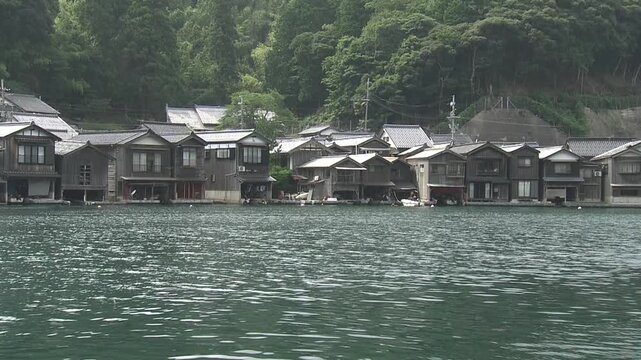 Footage panning from right to left across the *funaya* (boathouses) in Ine Town, Kyoto Prefecture.