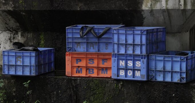 Stacked blue and red plastic crates in an outdoor storage area