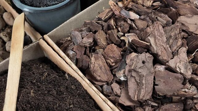 Cardboard boxes with houseplant repotting materials. Flower potting mix, drainage materials, bark