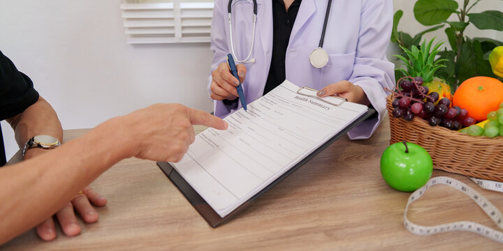 Doctor pointing at health summary form during nutrition consultation with patient