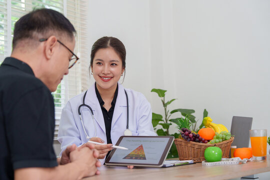 Asian female doctor explaining healthy eating pyramid on tablet to patient