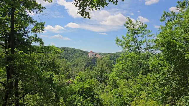 Beautiful timelapse of Vranov nad Dyj&iacute; Castle, a magnificent Baroque landmark in South Moravia, Czech Republic. Perched dramatically on a rocky cliff above lush forests under a blue summer sky with dr