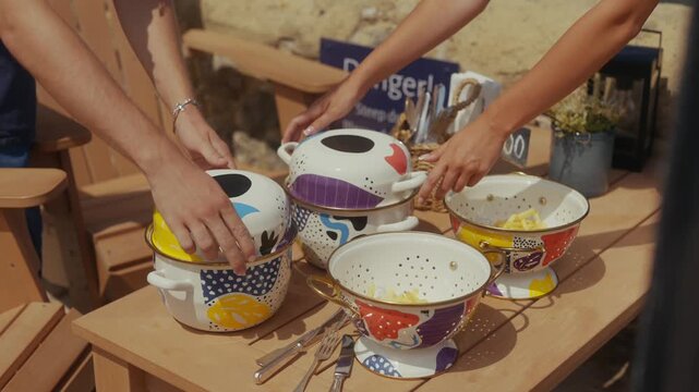 Colorful bowls of pasta served on a wooden table outdoors