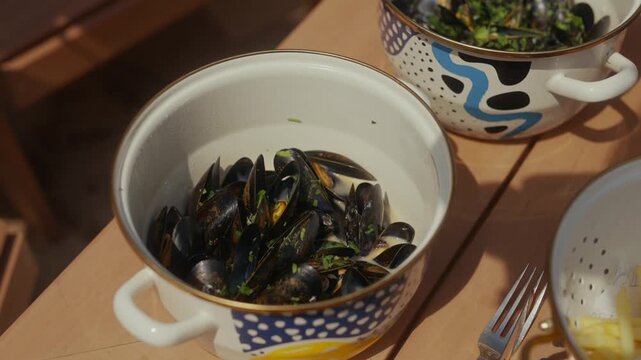 Close up of mussels in a patterned bowl on a wooden table