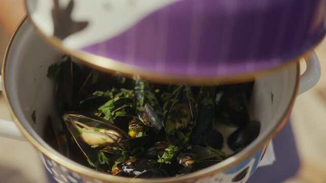 Steaming mussels in a white pot with fresh parsley garnish