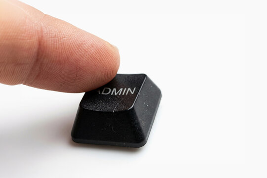 Finger pressing a black computer key labeled ADMIN