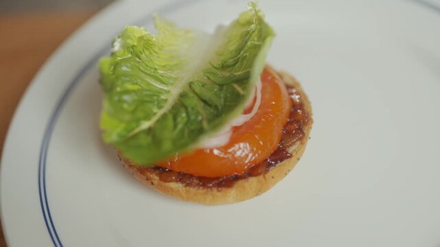 Close up of a savory tart with salmon and lettuce on a plate