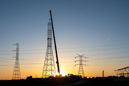 Transmission Tower Construction with Mobile Crane at Sunset