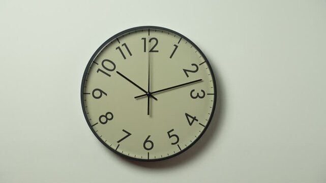Modern wall clock time lapse. Clock on white wall. Black wall clock with running time pointers.