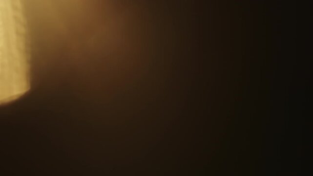 Slow motion real lens flare from back sunlight over dark background for overlay
