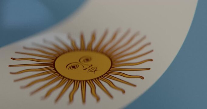 High quality 4K seamless loop of the Argentine national flag waving in slow motion. Detailed cloth fabric texture, Sol de Mayo, and smooth wave motion for news, culture, and national celebrations.