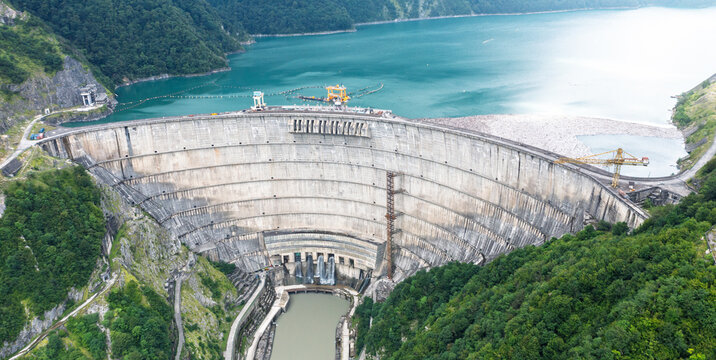 Enguri dam aerial view of spillway basin and curved concrete structure for water management, hydroelectric engineering, flood control and infrastructure.