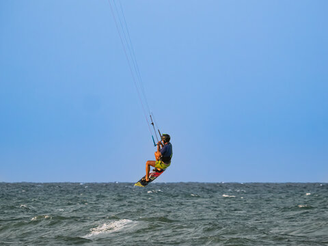Kai, a surfer, soaring through the air on Cullera beach (Valencia, Spain)