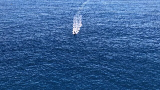 Aerial View of Motorboat Speeding Across Deep Blue Ocean Water
