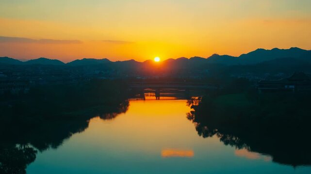 A tranquil river at dusk with a beautifully reflected sunset.