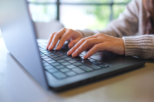 Closeup image of a woman working and typing on laptop computer