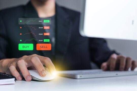 Close Up Of Hand Clicking Computer Mouse To Navigate Trading Hologram At Workspace