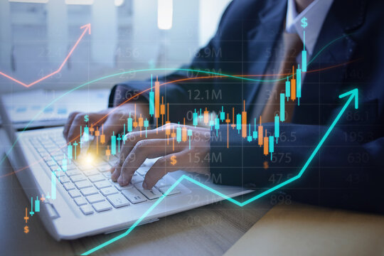 Professional Investor Typing on Laptop To Analyze Financial Growth Hologram at Workspace