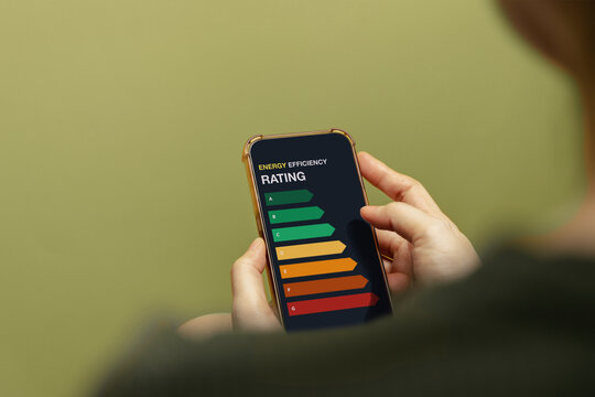 erson holds a smartphone displaying an energy efficiency rating scale