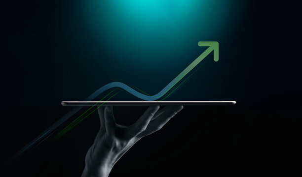 A hand presents a digital tablet beneath a rising graph and arrow