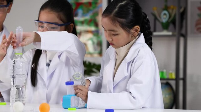 Asian Students Conducting Science Experiment with Plastic Bottles in Classroom