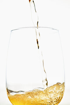 Pouring White Wine into a Glass against White Background