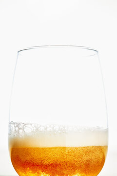 Glass of golden beer with foam isolated on white background