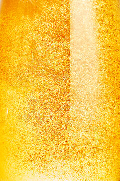 Macro background of golden carbonated beer liquid with tiny bubbles