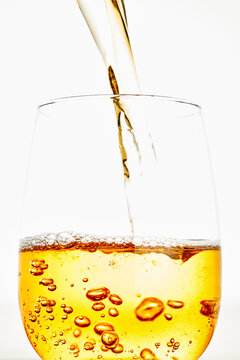Pouring Golden Liquid Beverage into Glass