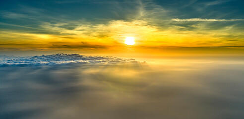 Obraz premium Magnificent sunrise above a vast sea of clouds, with golden sunlight streaming across the mist to create a dramatic and peaceful atmosphere