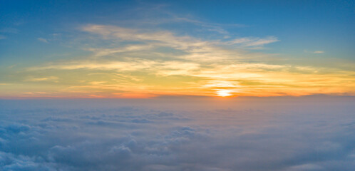 Obraz premium Magnificent sunrise above a vast sea of clouds, with golden sunlight streaming across the mist to create a dramatic and peaceful atmosphere