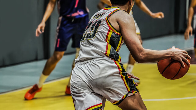 Basketball player dribbling the ball during an indoor competitive game