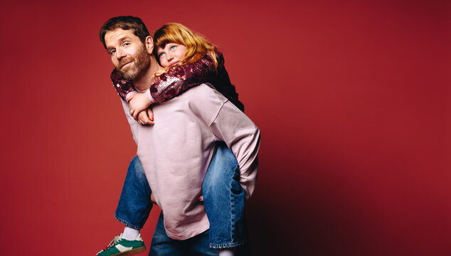 Piggyback fun makes this father and daughter family portrait feel playful and close
