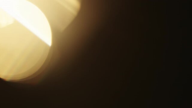 Slow motion real lens flare from back sunlight over dark background for overlay
