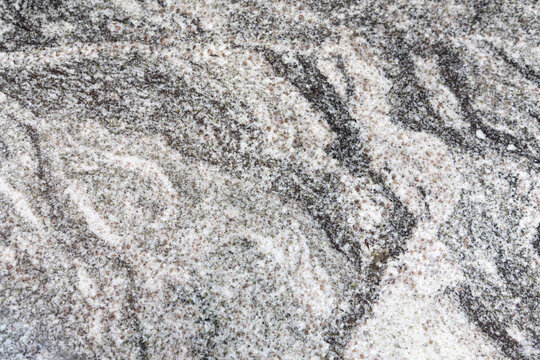 Viscount White granite (also known as Viscon White or Cosmic White). It is a highly durable igneous rock quarried primarily in India. It is recognizable by its dynamic, flowing wave patterns of white