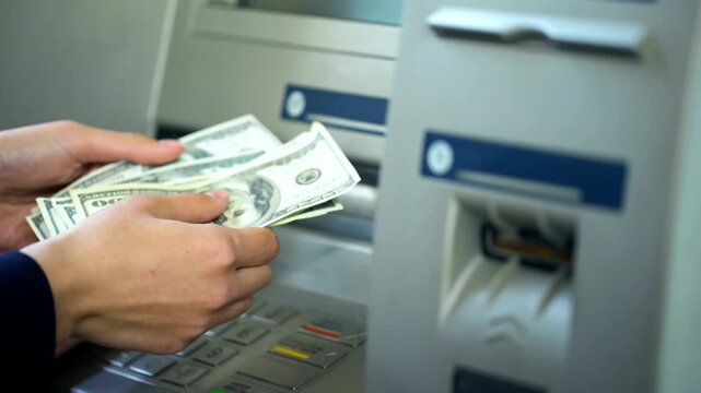 Lady counting dollars withdrawn from ATM machine and putting cash in purse for easy banking and financial transaction in 4K Ultra HD footage
