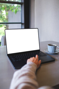 Vertical mockup image of a woman working on laptop computer with blank white desktop screen in cafe