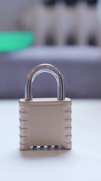 Close-up of a child's hand pressing down on a metal padlock to secure it. The action symbolizes protection, safety, and data security