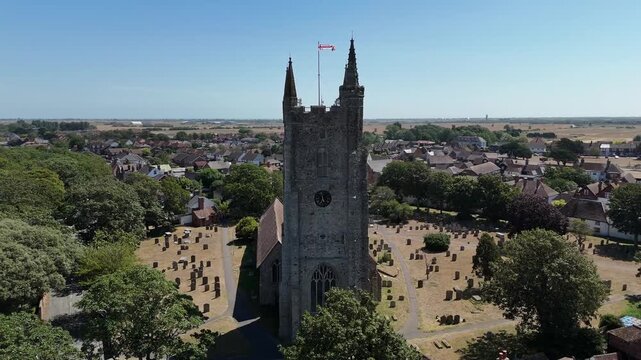 Aerial view of an old stone church in rural England during a clear summer afternoon
