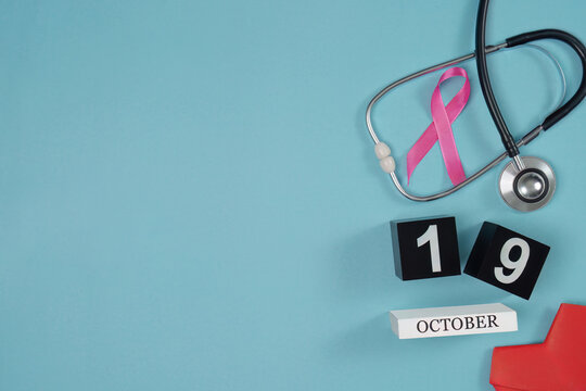 Breast cancer awareness concept with pink ribbon stethoscope and October 19 calendar on blue background