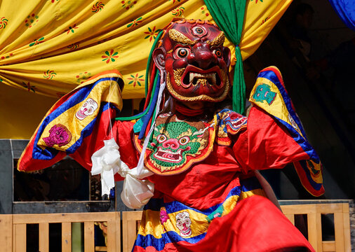 Bhutan, In the village of Bumthang, a monk in colorful costumes dance during the annual Jakar festival.
