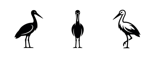 Obraz premium Silhouettes of three storks or wading birds, two standing, one in profile