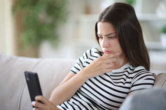 Mistrustful teenage girl checking online content on phone