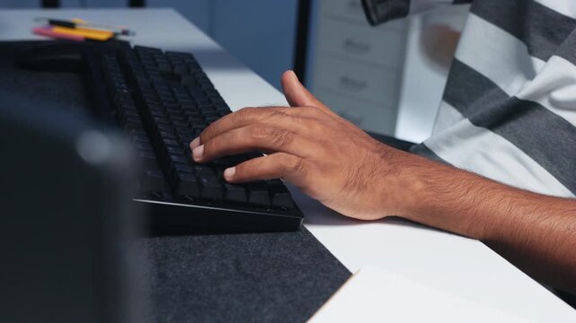 Close-up of Male Computer Programmer hand typing on keyboard while working on coding task at desk in tech office at night. Writing code, developing application, Ai machine learning LLM Concept.