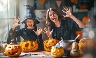 Obraz premium Happy Kids in Costumes Celebrating Halloween with Pumpkin Carving
