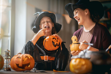 Obraz premium Happy Family Enjoying Halloween Pumpkin Carving and Candy