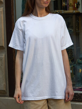 Woman wearing a plain white t-shirt and beige shorts outdoors
