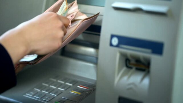 Woman counting euros withdrawn from ATM machine and putting cash in purse for convenience and easy banking transaction in 4K Ultra HD footage
